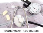 stethoscope and pills on cardiograms - stock photo