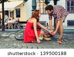 man fell down from the bicycle and woman help him to collect products - stock photo