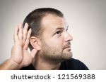 A young man trying to hearing the sound around him - What did you say? - stock photo