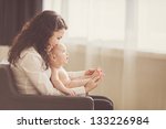 happy mother holding her baby and playing with him indoors - stock photo
