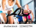Young People - group of women and men - doing sport Spinning in the gym for fitness - stock photo