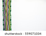 Small photo of Mardi Gras beads, masks and banner reading Mardi Gras in traditional festive colors on a white background in horizontal or landscape format with lots of copy space