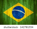  - stock-photo-brazil-flag-or-green-yellow-blue-and-white-brazilian-banner-on-wooden-background-142781554