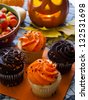 Halloween cupcakes with orange and black icing on orange napkin. - stock photo