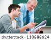 male student with a teacher in classroom - stock photo
