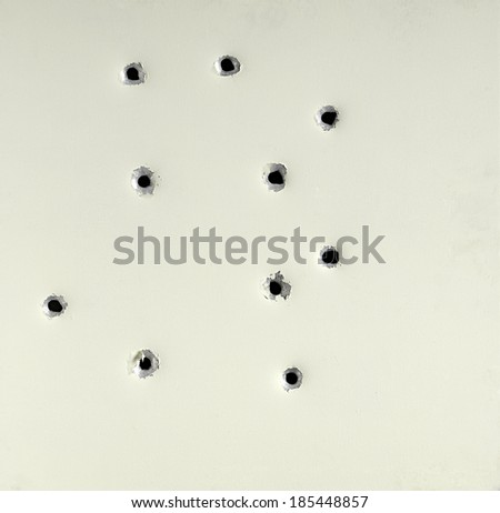 Bullet holes from a firearm in a metal plate