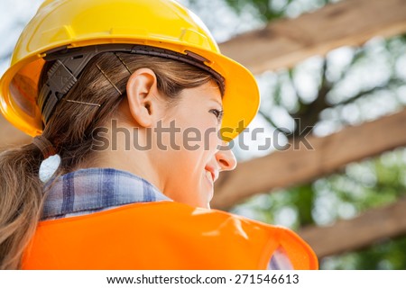 Rear view of female construction worker looking away at site