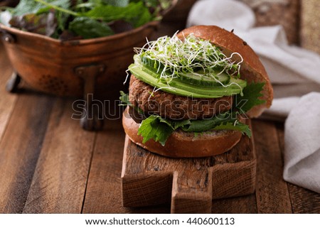 Grilled vegan bean burger with avocado, salad and cucumber