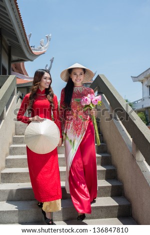 Vertical image of two girls going downstairs in the temple