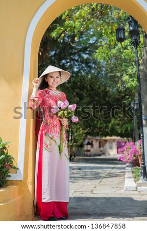 Vertical portrait of a beautiful young lady with lotus bouquet outside