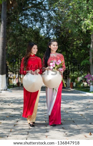 Women in traditional red dresses walking in the park