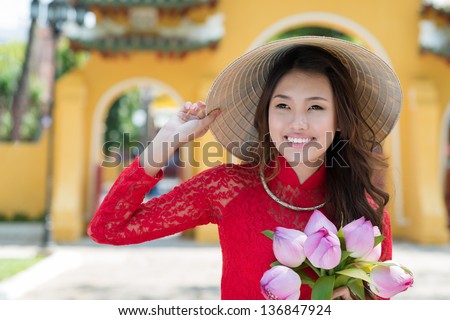 Close-up of an asian young woman in traditional wearing with lotus in hands