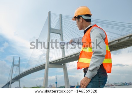 Profile view of a foreman thinking about bridge reconstruction outside