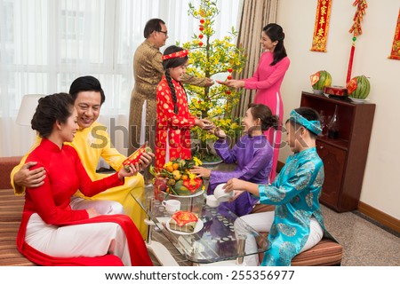 Asian family in ao dai dresses celebrating Tet at home
