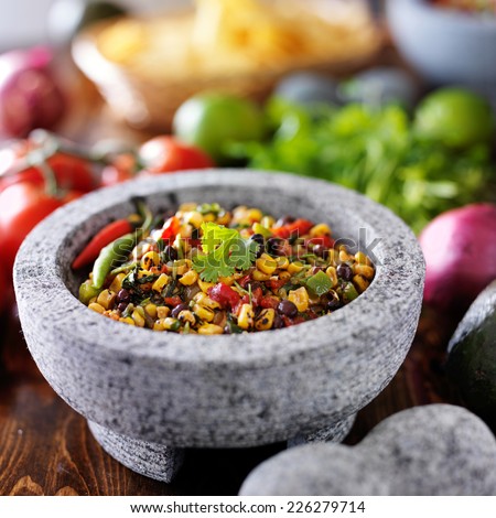fire roasted corn and black bean salsa in stone molcajete