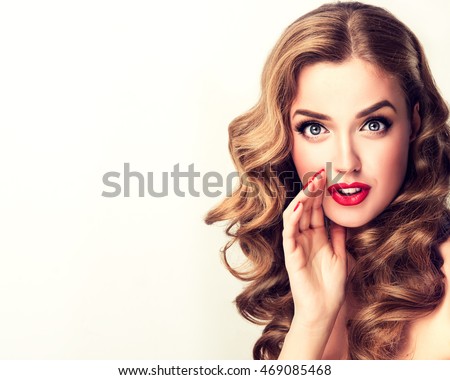 Beautiful girl with bright makeup and curly hair telling a secret .Portrait young happy woman who is calling to someone .Funny girl model whispering about something. Expressive facial expressions