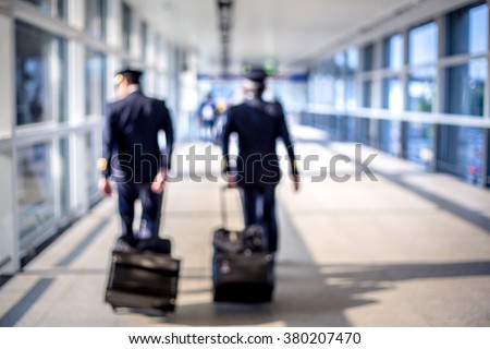 Blurred image of pilots walking at the airport terminal