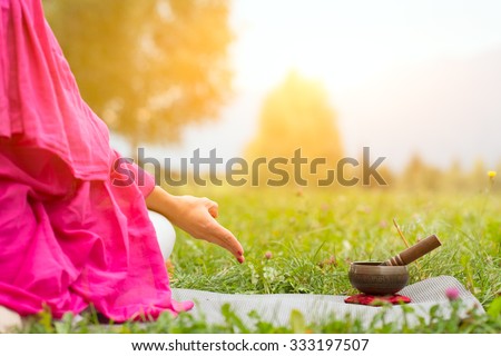 Tibetan bell beside yoga position in a meadow