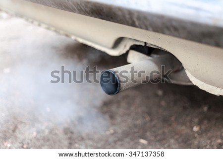 Combustion fumes coming out of car exhaust pipe