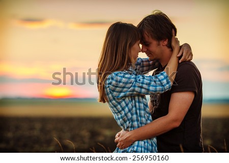 https://thumb1.shutterstock.com/display_pic_with_logo/1129805/256950160/stock-photo-couple-embracing-at-sunset-on-the-countryside-young-romantic-man-and-woman-standing-and-hugging-256950160.jpg