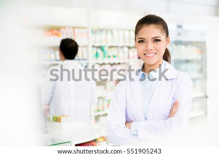 Smiling asian woman pharmacist in pharmacy (chemist shop or drugstore)