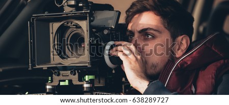 Behind the scene. Cameraman shooting the film scene with his camera on outdoor location