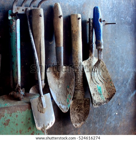stock-photo-old-dirty-farm-metal-garden-tools-as-shovels-and-rakes-hanging-on-the-wall-on-nails-524616274.jpg