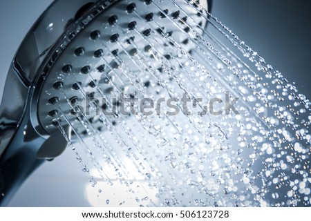 Image of a modern shower head splashing water close up background.