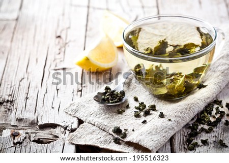 cup of green tea and lemon on rustic wooden table