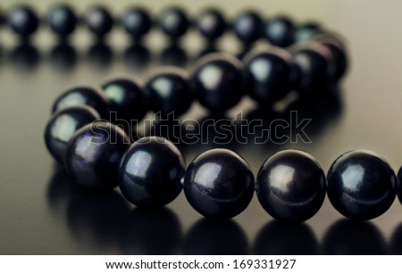 necklace of black pearls on a black background