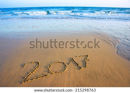 2017 written in sand, on tropical beach
