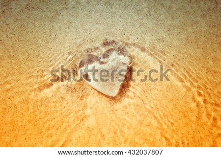 Rippled under water Heart, blurred wave action on beach
