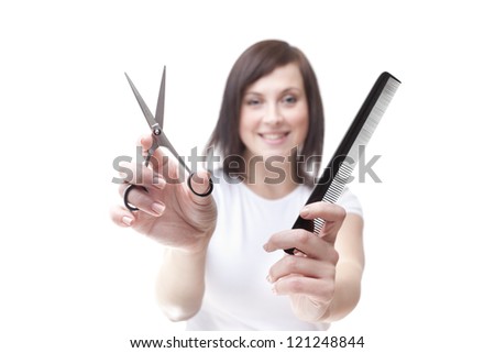 Young hairdresser holding scissors and comb isolated