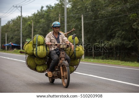 DONG NAI PROVINCE, VIETNAM - NOVEMBER 3: Unidentified man transporting jackfruits on an overloaded scooter in Dong Nai Province, Vietnam on November 3.