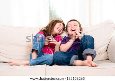 Children listening to music while sitting on a couch