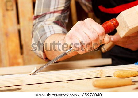 Hands holding a round wooden mallet and wooden handled chisel. - stock ...