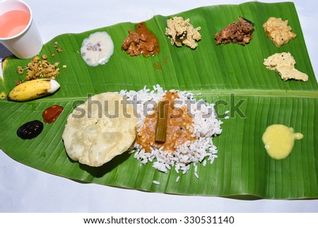 Traditional Onam sadhya, boiled rice, served with curries Parippu, Sambar, Rasam, Pulisseri, Kaalan, Avial, Thoran, Olan, Pachadi, Naranga curry, Papadum, Payasam, Banana, Yogurt or Buttermilk, chips 