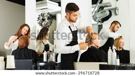 Hairdresser cuts young girl's hair in the beauty salon