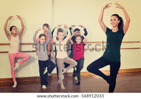 Young happy ballet dancers exercising in ballroom