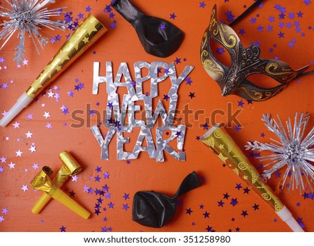 Happy New Year Party Decorations on festive orange wood table.