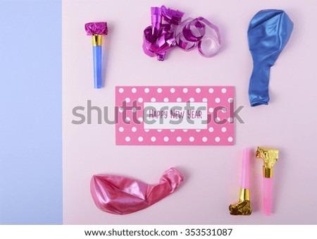 Modern overhead Happy New Year party decorations in pink and blue theme with greeting text.