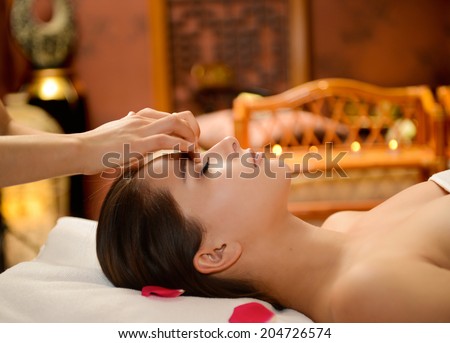 Young attractive girl having facial massage at spa resort