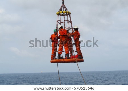 workers lifted by crane offshore platform stock photo