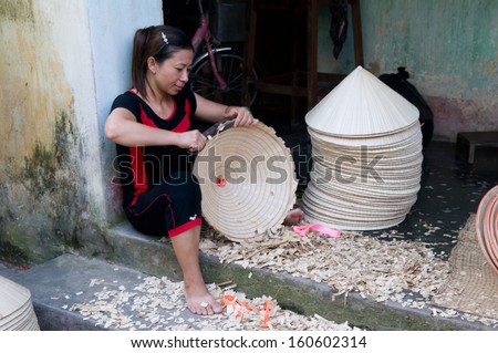 HANOI, VIETNAM, AUGUST 12: Unidentified woman makes conical hat on August 12, 2013 in Hanoi, Vietnam. Making conical hat is a traditional handicraft job in Chuong village, Thanh Oai district, Hanoi