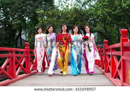 HANOI, VIETNAM, DECEMBER 20: Vietnamese girls with Ao Dai on The Huc bridge on December 20, 2012 in Hanoi, Vietnam. Ao dai is famous traditional custume for woman in VIetnam.