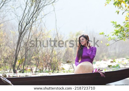 Vietnamese girl with traditional dress (ao dai) and conical hat in Yen stream in Hanoi,