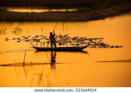 Fisher on boat in water season in sunrise in Dong Thap, Vietnam