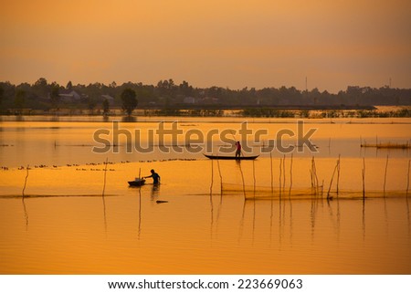 Fisher on boat in water season in sunrise in Dong Thap, Vietnam