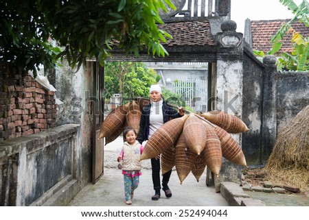 HUNGYEN, VIETNAM - FEB 7 :Unidentified woman was carring tool use to catch fish on February 7, 2015 in HungYen, Vietnam. Weaving this tools is traditional occupation in Hung Yen province.