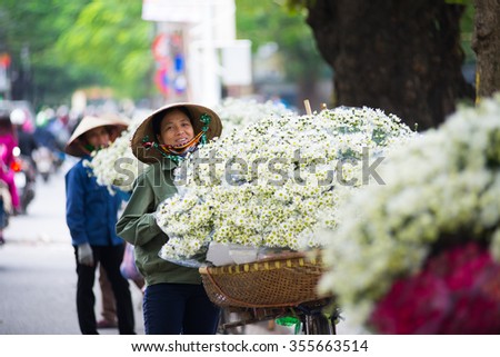 HANOI, VIETNAM - NOVEMBER 25: White daisy flower vendor in a street in Hanoi on November 25, 2015 in Hanoi, Vietnam. In Vietnam white daisy flowers bloom in November.